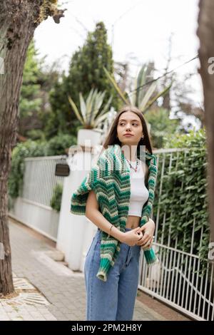 Eine junge Frau mit Oberteil und Strickpullover, die auf der Straße in Istanbul steht, Stockbild Stockfoto