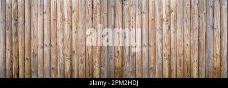 Privatzaun aus dickem, rundem Holz mit starker Holzmaserung Stockfoto