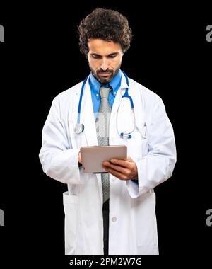 Porträt eines gutaussehenden Arztes mit einer auf Schwarz isolierten Digitaltablette Stockfoto