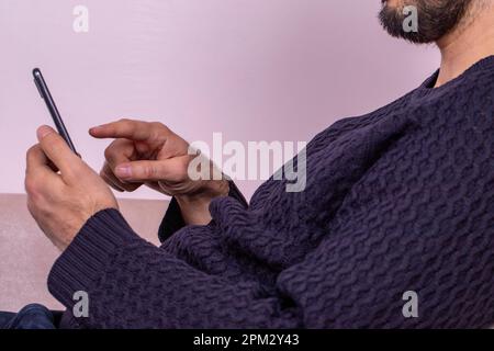 Glücklicher Mann, der auf sein Handy schaut. Ein weißer Mann erhält eine gute Nachricht Stockfoto