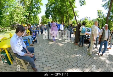 Leute gehen, sitzen auf Bänken und entspannen sich im Stadtpark. Muttertag. 12. Mai 2019. Taras Shevchenko Park, Kiew, Ukraine Stockfoto