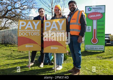 Slough, Großbritannien. 11. April 2023. Streikende Juniorärzte der British Medical Association (BMA) stehen neben Plakaten, die eine Gehaltssanierung an einer offiziellen Streikpostenlinie außerhalb des Wexham Park Hospital fordern. BMA-Ärzte in der Ausbildung fordern eine Gehaltserhöhung von 35 %, um die Inflation seit 2008 auszugleichen. Wexham Park Hospital ist ein großes NHS-Krankenhaus in Slough, das vom Frimley Health NHS Foundation Trust verwaltet wird. Kredit: Mark Kerrison/Alamy Live News Stockfoto