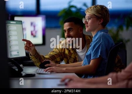 Zwei Geschäftskollegen An Schreibtischen In Office Arbeiten Zusammen Bis Spät In Die Nacht Am Projekt Stockfoto