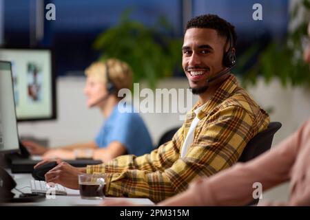 Porträt Eines Business-Teams, Das Headsets Trägt Und Bis Spät In Die Nacht Im Customer Support Center Arbeitet Stockfoto