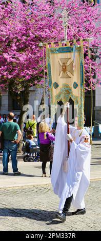 Ostersonntagsumzug mit Teilnehmer in langen Bademänteln mit einem Kirchenbanner Santander Cantabria Spanien, 9. April 2023 Stockfoto