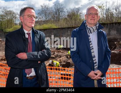 Trier, Deutschland. 11. April 2023. Der Innenminister von Rheinland-Pfalz, Michael Ebling (l, SPD), und der Oberbürgermeister von Trier, Wolfram Leibe (SPD), stehen an dem Ort, an dem eine römische Hilfe gefunden wurde. Das 1,20 Meter hohe Kalksteinrelief von Cautes, Begleiter des römischen gottes der Lichter Mithras, wurde während archäologischer Ausgrabungen auf der Baustelle der neuen Feuerwache gefunden. (Zu dpa „spektakuläre Entdeckung“ - Kultstätte mit römischem Relief entdeckt) Kredit: Harald Tittel/dpa/Alamy Live News Stockfoto