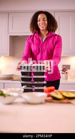 Frau In Der Küche Trägt Fitnesskleidung Und Macht Eine Menge Gesunder Mahlzeiten Für Den Gefrierschrank Im Voraus Stockfoto