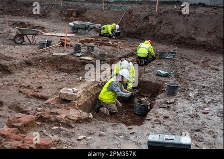 Trier, Deutschland. 11. April 2023. Männer sind mit archäologischen Ausgrabungen auf der Baustelle der neuen Feuerwache beschäftigt, wo ein 1,20 Meter langes Kalksteinrelief von Cautes, Begleiter des römischen gottes des Lichts Mithras, gefunden wurde. (Zu dpa 'spektakuläre Entdeckung' - Kultstätte mit römischem Relief entdeckt) Kredit: Harald Tittel/dpa/Alamy Live News Stockfoto