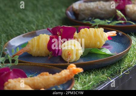 Frittierte Garnelen, Frühlingsrollen und anderes frittiertes Zeug, Nahaufnahme von asiatischem Essen am Stand des Farmers Street Food Markts. Stockfoto