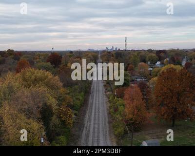 Ein Luftbild von Eisenbahnstrecken, die im Herbst in die Innenstadt von Indianapolis führen und von bunten Bäumen umgeben sind Stockfoto