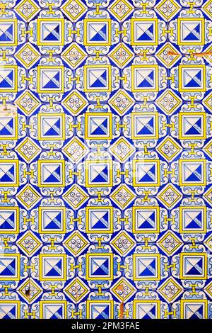 Blaue, weiße und gelbe Fliesen mit geometrischem Muster an einer Wand. Cadiz, Andalusien, Spanien Stockfoto