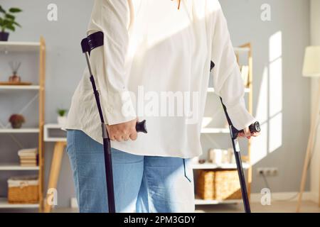 Eine verletzte, übergewichtige, behinderte Frau, die Krücken zum Gehen benutzte Stockfoto