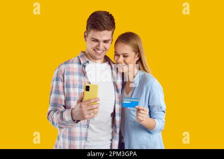Junge, positive Weiße kaufen über Apps auf dem Mobiltelefon ein Stockfoto
