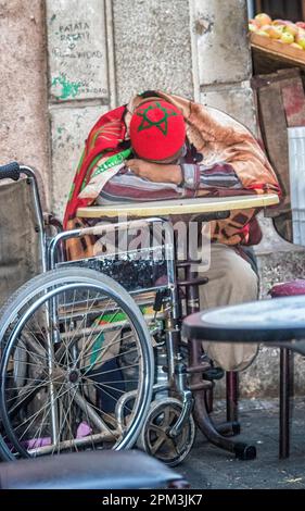 Ein Mann mit Rollstuhl ruht in einem Café in Casablanca, Marokko. Stockfoto