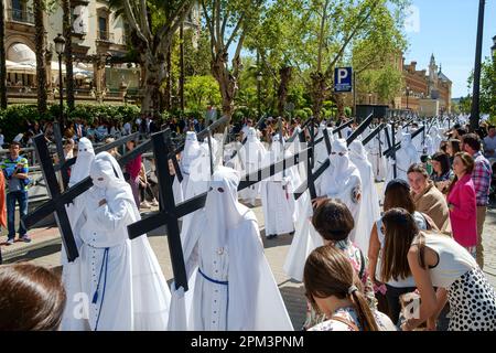 Sevilla Spanien. Heilige Woche, Semana Santa. Die "Nazarenen" der Bruderschafts-Parade brachten die Straßen am Palmensonntag, Domingo de Ramos auf Spanisch. Stockfoto