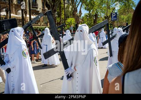 Sevilla Spanien. Heilige Woche, Semana Santa. Die "Nazarenen" der Bruderschafts-Parade brachten die Straßen am Palmensonntag, Domingo de Ramos auf Spanisch. Stockfoto