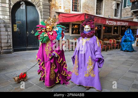 Venedig Karneval, kostümierte Teilnehmer in farbenfrohen venezianischen Kostümen machen einen Spaziergang durch die Straßen, Venedig, Italien Stockfoto