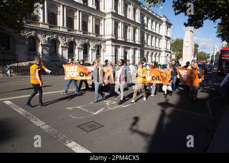 Aktivisten von „Just Stop Oil“ versuchen, ein Banner vor dem Verkehr in Westminster im Zentrum von London zu halten. Stockfoto