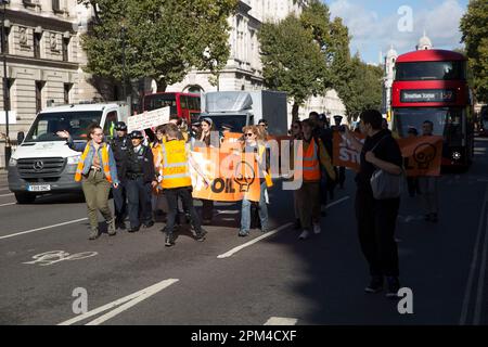 Aktivisten von „Just Stop Oil“ versuchen, ein Banner vor dem Verkehr in Westminster im Zentrum von London zu halten. Stockfoto