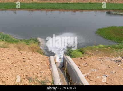 Ablaufrinne hinter dem Werkswasserfluss in den Aufbereitungsteich. Stockfoto