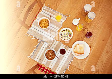 Sieht gut genug zum Essen aus. Aus einem hohen Winkel, ein leerer Tisch mit Frühstücksspeisen. Stockfoto