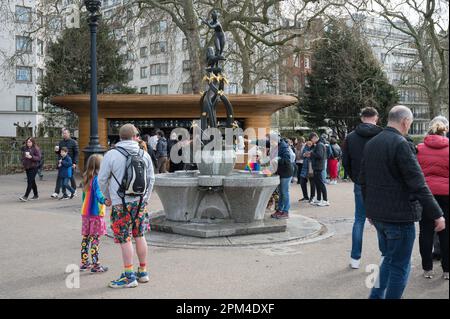 Touristen und Tagesausflügler im Green Park am Diana Fountain, auch bekannt als Diana der Treetops Skulptur, von Estcourt J Clack. Green Park, London, Großbritannien Stockfoto