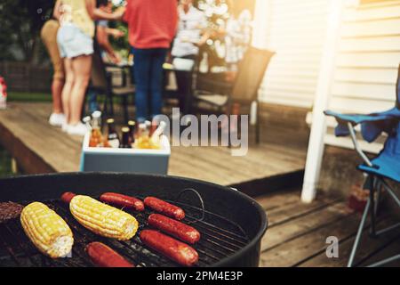 Es ist das Wochenende, Zeit zum Grillen. Eine Gruppe von Freunden, die ein Barbecue im Hof veranstalten. Stockfoto