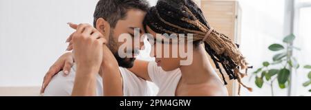 Seitenansicht eines bärtigen Mannes und einer jungen afroamerikanischen Frau mit Dreadlocks, die Hände umschließen und halten, Banner, Stock Image Stockfoto