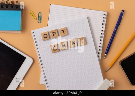 Arbeits- und Studienhintergrund mit Hilfe eines ChatGPT-bot. Wörter in Holzbuchstaben. Tischansicht mit freiem Notizbuchbereich. Chat-GPT zum Arbeiten und Erstellen. Ukraine, Kiew - 21. Februar 2023 Stockfoto