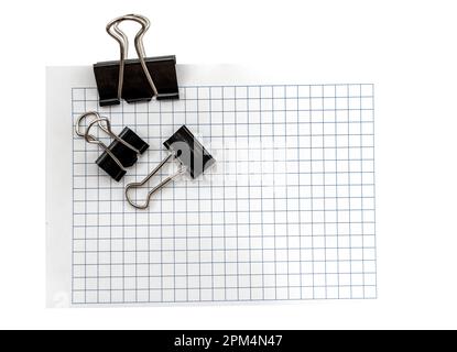 Ein Blatt Papier in einem Käfig für Notizen mit einer Büroklammer auf weißem Hintergrund. Einträge. Notizen. Erinnerung Stockfoto