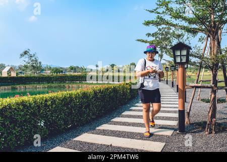 KANCHANABURI -THAILAND, MÄRZ 30 ,2023 : Unbekannte Touristen kommen zu Besuch und machen Fotos mit einem Restaurant und Café mit einem wunderschönen Garten Stockfoto