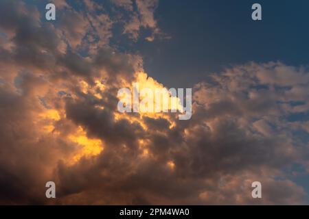 Perfekter Hintergrund helle goldorange Wolken, die von Sonnenlicht beleuchtet werden. Sommerabend mit hellem Himmel, der Ihre Fotos überlagert Stockfoto