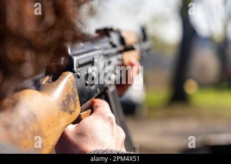 Eine Frau zielt mit einem AK-47 Kalaschnikov Sturmgewehr Stockfoto