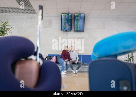 Ein Paar küsst sich, während es am Flughafen in sein Flugzeug steigt. Stockfoto