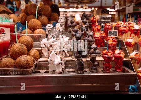 Frisch geschnittene geschälte Mischung von Früchten verschiedener Arten in Behältern mit Gabeln auf einem Marktstand, gesunde Ernährung, nahrhaftes Straßennahrung, hoher Vitamingehalt Stockfoto