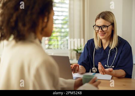 Der Arzt füllt das Formular für den medizinischen Bericht über die medizinische Versorgung von Patienten während der Verabredung aus Stockfoto