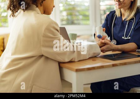 Nahaufnahme des Arztes misst die Temperatur des Patienten mit einem berührungslosen Thermometer in der Klinik Stockfoto