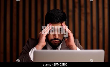 Geschäftsmann mit Händen hinter dem Kopf, der in einem komfortablen Büro ruht. Stockfoto