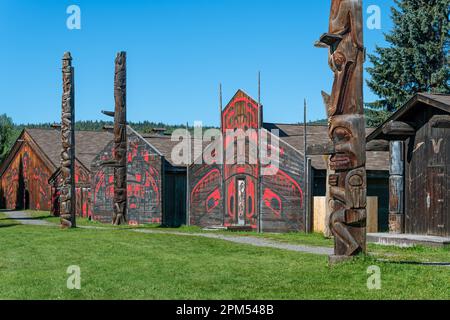 Traditionelle lange Häuser und Totempfähle der Ureinwohner der Gitxsan First Nations, Ksan historisches Dorf, Old Hazelton, Kanada. Stockfoto