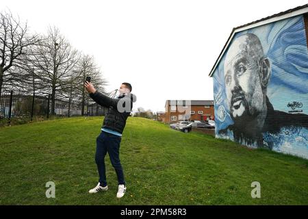 Ein Manchester City-Fan fotografiert ein Wandbild des Manchester City Managers Pep Guardiola vor dem Viertelfinale der UEFA Champions League im Etihad Stadium, Manchester. Foto: Dienstag, 11. April 2023. Stockfoto