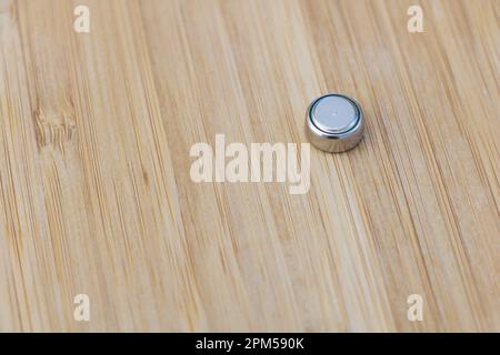 Nahaufnahme einer LR44-V-Batterie auf einer Holzfläche. Selektiver Fokus Stockfoto