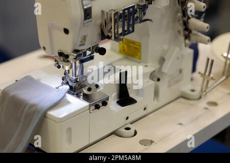 Nahaufnahme der industriellen Decknähmaschine. Selektiver Fokus. Stockfoto