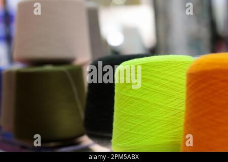 Mehrfarbige Wollgarnkonen für die Textilindustrie. Selektiver Fokus. Stockfoto