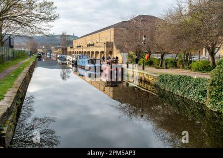 Schmalboote, die sich im stillen Wasser des Huddersfield Broad Canal in Huddersfield, West Yorkshire, England, Vereinigtes Königreich, widerspiegeln Stockfoto