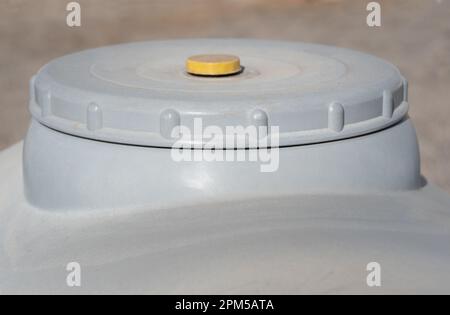 Detailaufnahme eines grauen Kunststoff-Wassertanks. Sie können den Deckel und einen Teil des Tanks sehen. Stockfoto