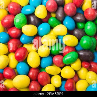 Nahaufnahme des Texturhintergrunds bunter Süßigkeiten. Bunte Schokoladenstücke mit Bonbons in einer Schüssel (selektiver Fokus) Stockfoto