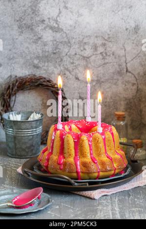 Orangefarbener Vanillekuchen mit pinkfarbenem Glasur, Osterdekor. Stockfoto