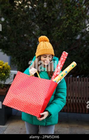 Frau hält weihnachtsgeschenke an Feiertagen in der Hand Stockfoto