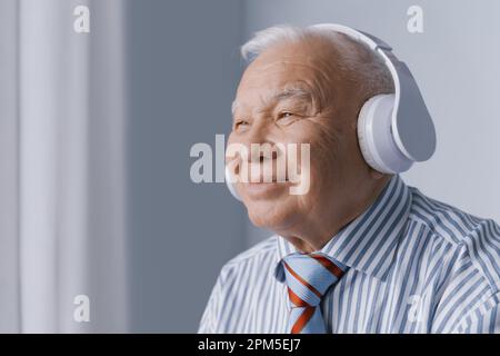 Ruhiger Geschäftsmann, der Kopfhörer trägt und Audio hört Stockfoto