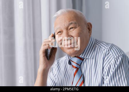 Senior Mann trägt formelle Kleidung und benutzt Smartphone Stockfoto